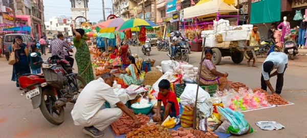 बालक चौक के पास दीये व अन्य सामग्री की खरीदी करता हुआ ग्राहक।