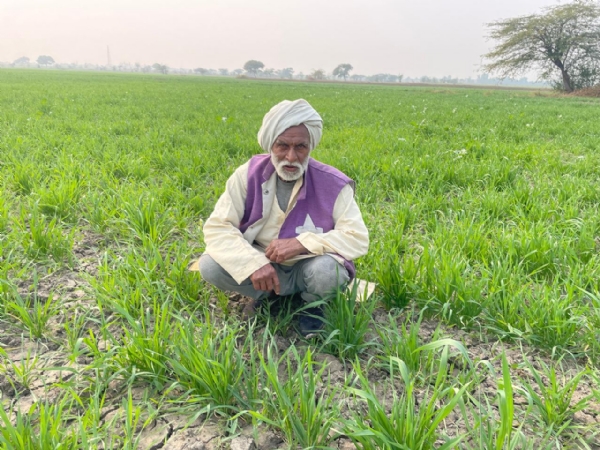 खेत में बैठा किसान