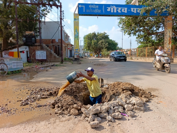 शहर के पोस्ट आफिस वार्ड के पास लिकेज दुरुस्त करते निगम कर्मचारी।