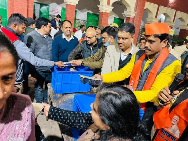 District Magistrate distributing food packets among the devotees